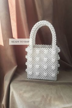 Shrimps bag Aesthetic tote bag for woman. Vintage pearl beaded white retro bag that will decorate your wedding day. Amazing wedding gift for bride. SIZE: *Height: 33 cm *Height without handles: 19 cm *Width: 16.5 cm *Lateral width: 10 cm *Handle drop: 14 cm *Weight: 750g 🔥PROCESSING TIME 3-4 days MATERIAL: white acrylic pearl beads 8mm. LINING White satin🤎 The bag can be made with a LINING with a POCKET or without a lining. Choose VARIATIONS when you place an order☝ With every pearl bag you'll get jewelry GIFT - beaded jewelry🎁 In addition to the gift, a hand-signed POSTCARD with a message from the purse is attached to the order✉ If this is a present, be sure to write me the name of the recipient✒ More pearl bags: https://www.etsy.com/shop/VitakaJewelry?ref=seller-platform-mcnav§ion_id= Indigo Bag, Gold Chain Handbag, Wedding Tote Bag, Woman Aesthetic, Aesthetic Tote Bag, Wedding Tote, Retro Bags, Wedding Purse, Bridal Clutch