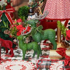 a table topped with green and red christmas decorations