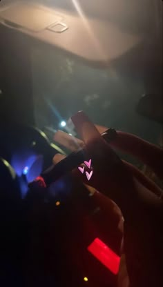 a person holding a cell phone in their hand with the light shining on them behind it