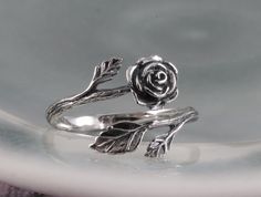 "This sterling silver rose ring is beautifully sculptural. It's oxidized to show the graceful flow of each petal. The rose is considered the \"Queen of all Flowers\"  and has been cultivated for thousands of years for its magnificent beauty and scent. A wonderful gift of love, or for one who loves the beauty of nature. This ring, as shown, is a size 7 and is fully adjustable. If you have a specific size in mind, please leave a note and I will re-size it for you." Silver Rose Ring Jewelry, Silver Rose Design Jewelry For Promise Ring, Sterling Silver Rose Flower Jewelry, Sterling Silver Rose Flower Ring With Rose Design, Adjustable Silver Jewelry With Rose Details, Adjustable Sterling Silver Flower Ring With Rose Design, Adjustable Rose Sterling Silver Jewelry, Adjustable Sterling Silver Rose Design Ring, Adjustable Sterling Silver Jewelry In Rose Color