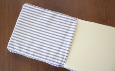 a piece of cloth is laying on top of a wooden table with white and gray stripes