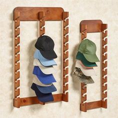 three hats are hanging on the wall in front of two wooden racks with hooks holding hats