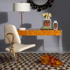 a white chair sitting in front of a table with a mirror on top of it