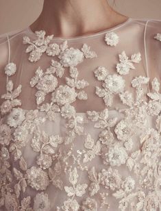 the back of a woman's wedding dress with flowers on it and sheer fabric