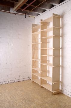 an empty room with white brick walls and wooden shelves