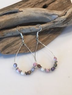 These beautiful earrings have a fun boho style! Made with Silver Teardrop hoop wires with gorgeous 6mm Faceted gemstones and gorgeous silver spacers. The earring itself measures approximately 2 inches in length by one inch wide. The ear wires are lead and nickel free. Colors of pale blues, lavender,pink, grays and cream.. Beautiful statement earrings that can be dressed up or down and worn throughout the year! Your Boho style earrings will come packaged in a pretty gift box, ready for giving or Bohemian Teardrop Hoop Earrings With Ear Wire, Adjustable Wire Wrapped Bohemian Teardrop Earrings, Bohemian Adjustable Wire Wrapped Teardrop Earrings, Wire Wrapped Teardrop Earrings For Festival, Teardrop Wire Wrapped Earrings For Festival, Silver Teardrop Beaded Earrings Bohemian Style, Multicolor Teardrop Hoop Earrings Bohemian Style, Bohemian Wire Wrapped Dangle Teardrop Earrings, Bohemian Teardrop Beaded Earrings