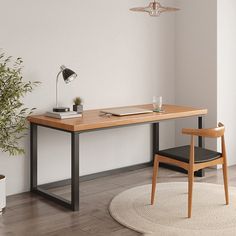 a wooden desk sitting next to a chair and potted plant on top of a hard wood floor