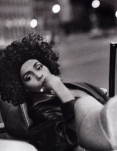 a black and white photo of a woman with curly hair