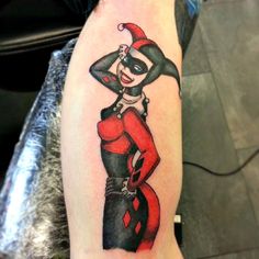 a person with a tattoo on their arm wearing a red and black clown costume,