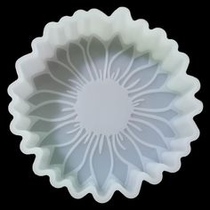 a white flower shaped bowl sitting on top of a table