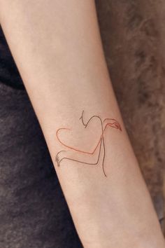 a woman's arm with a red heart tattoo on the left side of her arm