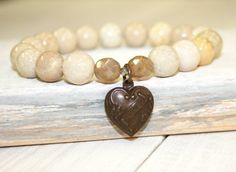 "Creamy River stone Stretch Bracelet with Heart Charm This River stone bracelet has an etched, heart shaped charm that says \"I love U\". The cream beads are 10mm. The charm is nestled in between 2 opalescent Czech glass beads. This earthy stretch/stack bracelet is a really versatile piece. It can be worn with other stacking bracelets, or leather wrap bracelets, but makes a simple statement when worn by itself. This is a medium size bracelet, measuring 7.25\". Your bracelet will be shipped in a Cream Stone, Life Jewelry, Bracelet With Heart, Bracelet Heart, I Love U, River Stones, Bracelet Gemstone, Leather Wrap Bracelet, Organza Gift Bags