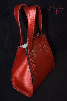 Bogo Leather Handbag, a mini classic purse made of American chrome tanned Cowhide leather and polished with top coat to make it resistance to water. The interior part of the bag is logo printed on lining. Inside the purse there is one small flat pocket. Bottom of the bag is supported by 4 supportive and protective metal feet. The bag opens and closes easily with magnetic snap on top.  Length x Height x Width  7 X 7 X 3.5 Handle (s) drop size: 4 inches Color: Starry ruby red Material: American ch Luxury Small Bags For Everyday Use, Luxury Small Bag For Everyday Use, Small Luxury Evening Bags, Small Luxury Evening Bag, Luxury Small Bag With Removable Pouch, Small Elegant Bag With Detachable Strap, Classic Top Handle Evening Bag As Gift, Chic Small Bags For Daily Use, Chic Small Bag For Daily Use