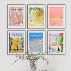 four framed new york posters on the wall above a table with vases and glasses