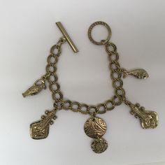 This is: An original vintage charm bracelet from the 60/70s. Lovely heavyweight gold tone brass curb bracelet with egraved ancient instrument, fish, urn and disc charms, fastening with a toggle clasp. Please see pics for size/weight/condition. Condition:  Great, no flaws. Any questions, please message me, thanks. I accept all returns - if you are not happy with your item, please message me before leaving feedback and I will be happy to deal with your concerns. I try my best to be as accurate as possible in my listings, but occasionally I will make a genuine mistake and will rectify it very quickly, just let me know, thanks. Antique Metal Bracelet With Charms, Vintage Charm Brass Bracelet, Gold Bohemian Charm Bracelet Nickel Free, Gold Symbolic Metal Charm Bracelet, Bohemian Gold Metal Charm Bracelet, Bohemian Gold Charm Bracelet With Lobster Clasp, Gold Bohemian Charm Bracelet With Lobster Clasp, Bohemian Gold Charm Bracelet In Brass, Bohemian Gold Brass Charm Bracelet