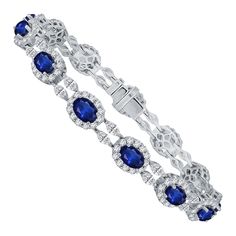 Elevate your jewelry collection with this exceptional bracelet, a true embodiment of timeless beauty and sophistication. It features thirteen resplendent oval-cut blue sapphires, collectively weighing 9.42 carats, each delicately framed by a halo of round diamonds. This combination of sapphires and diamonds evokes a sense of royalty, wisdom, and eternal love. Interspersed between the sapphires are pairs of marquise-cut diamonds, adding a touch of creativity and balance to the design. The combine Bracelet Tennis, Marquise Cut Diamond, Eternal Love, Marquise Cut, Blue Bracelet, Tennis Bracelet, Oval Cut, Timeless Beauty, Arm Band