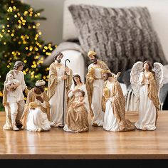 a group of figurines on a table in front of a christmas tree