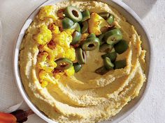 hummus and olives in a bowl on a table