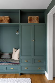 a room with blue cabinets and white pillows on top of the shelves in front of them