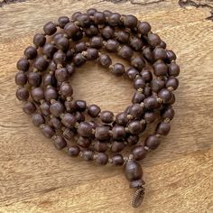 "📿Tulsi Mala handcrafted with Brown Tulsi beads. Suspended in the center is the engraved \"Krishna & Radha\" Guru Bead. When someone wears the tulsi mala, around your neck or around your wrist, you feel protected and focussed. It actually goes a long way in helping you deal with the stress of modern life.📿 🚪 Dimensions ( Approximately ) 🚪 📏Bead size: 11 MM - 12 MM 📏No. of beads: 108 Mala Bead + 1 Guru Bead 📏Mala Necklace Length: 50.0 - 51.0 inches 🚪 Pure Tulsi Beads Sourced from Vrindava Natural Wooden Beads Spiritual Bracelet, Spiritual Wooden Beads Jewelry For Meditation, Holistic Necklaces With 8mm Beads For Rituals, Spiritual Wooden Beads Jewelry For Healing, Artisan Jewelry With 108 Beads As Gift, Artisan Wooden Beads Bracelet For Meditation, Artisan Jewelry With 108 Beads Gift, Holistic Jewelry With 108 Beads For Rituals, Handmade Brown Beaded Bracelets For Ceremonial Use