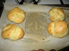 four rolls sitting on top of a piece of wax paper next to a burner