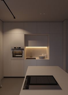 a modern kitchen with an oven, sink and countertop in the center is illuminated by recessed lighting