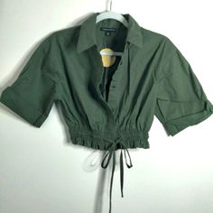 Here's The Details: - New-Nwt - Size: M - Color: Olive Green - Detail: Drawstring Waist - Hidden Button Down Front - Smock Waist - Cuff Sleeves - Lightweight Material - Measurement Approx: - Flat Pit2pit: 16.5" - Full Length: 15.5" Great Condition No Price Is Final Feel Free To Make An Offer Please Look At All Photos. Last Photo Is For Optics Of Advertisement. Sale Item Slightly Different. Disclaimer: Item(S) Are Represented To The Best Optics/Photos And Description Required For This Platform. A Green Drawstring Tops For Fall, Spring Utility Button-up Top, Casual Cotton Tops With Drawstring Tie, Utility Button-up Tops For Spring, Spring Cotton Blouse With Drawstring, Summer Cotton Drawstring Blouse, Summer Cotton Blouse With Drawstring, Casual Cotton Blouse With Drawstring, Cotton Tops With Drawstring Tie For Day Out