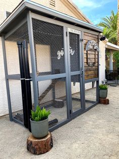 an outdoor chicken coop with two plants in the center and one planter on the outside