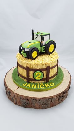 a cake with a tractor on it sitting on top of a tree stump