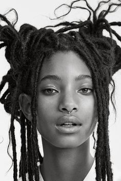 a black and white photo of a young woman with dreadlocks on her head