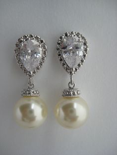 Classic cubic zirconia and pearl bridal earrings in rhodium plated brass setting. Earrings feature clear cubic zirconia teardrop ear post and a 10mm Swarovski cream pearl dangle drop. Total length of the earrings is 2.7 cms. For matching necklace click: https://www.etsy.com/listing/252977878/cream-pearl-and-crystal-bridal-necklace?ref=shop_home_active_10 For matching bracelet click: https://www.etsy.com/listing/253699301/classic-bridal-cream-pearl-bracelet?ref=shop_home_active_5 To browse my col Classic Crystal Bridal Earrings With Pearl Drop, Classic Pearl White Cubic Zirconia Bridal Earrings, Cubic Zirconia Pearl Drop Bridal Earrings For Formal Occasions, Formal Bridal Earrings With Pearl Drop And Cubic Zirconia, Formal Pearl Drop Bridal Earrings In Cubic Zirconia, Classic Cubic Zirconia Pearl Earrings For Wedding, Formal Pearl Drop Bridal Earrings With Cubic Zirconia, Classic Pearl Earrings With Cubic Zirconia For Wedding, Silver Pearl Drop Bridal Earrings For Wedding