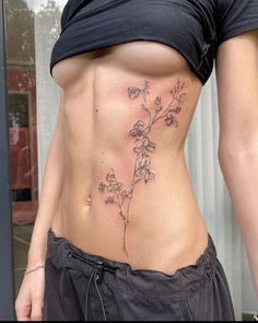 a woman's lower body with flowers on her stomach and behind her is a window