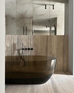 a bath tub sitting in the middle of a bathroom next to a wall mounted mirror