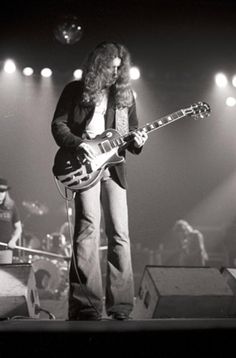 a man standing on top of a stage holding a guitar