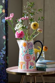 a vase filled with flowers sitting on top of a table next to a stack of books