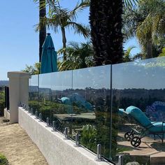 a glass fence with chaise lounges in the background