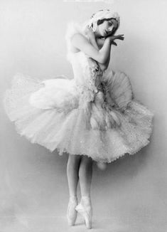 an old photo of a woman in a tutu skirt and tiara with her hands on her face