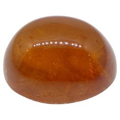 an orange stone with white dots on it's surface, against a white background