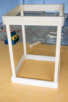 an unfinished wooden table sitting on top of a hard wood floor