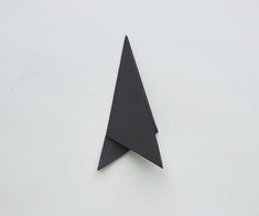 an origami paper airplane on a white surface