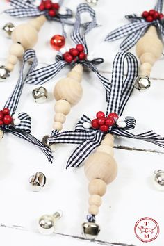 some bells are hanging from the side of a white table with red and black ribbon