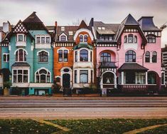 a row of multi - colored houses on the corner of a street