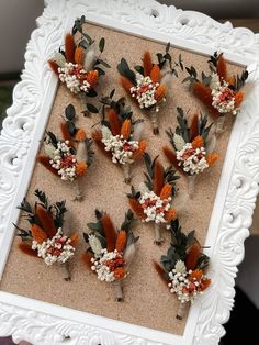 an arrangement of flowers arranged in a white frame