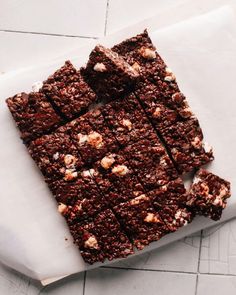 chocolate brownies with marshmallows are cut into squares on a piece of parchment paper