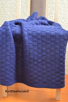 a blue blanket sitting on top of a wooden chair