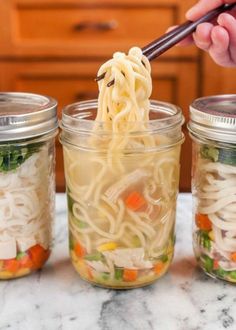 someone is spooning noodles out of the jar to put them in another container on the counter