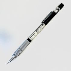 a black and silver pen sitting on top of a white table