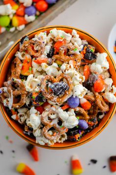 a bowl filled with halloween popcorn and candy