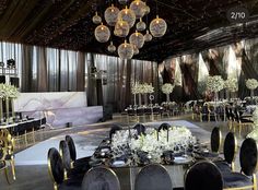 a banquet hall with tables, chairs and chandeliers set up for an event