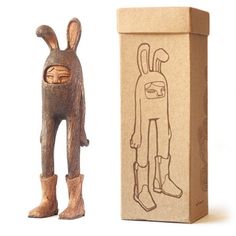 a wooden figure next to a cardboard box with an image of a rabbit on it